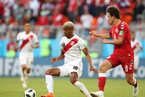 Andre Carrillo (trái, Peru) sutýt tung lưới Đan Mạch.