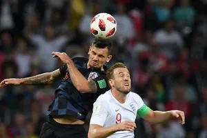Dejan Lovren tranh bóng với Harry Kane (phải, Anh)