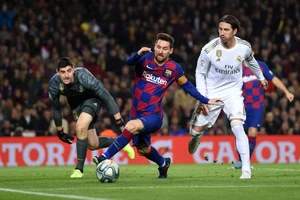 Lionel Messi tranh bóng với Sergio Ramos và thủ thành Thibaut Courtois