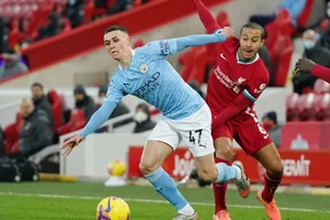 Phil Foden (trái) đi bóng qua Thiago 