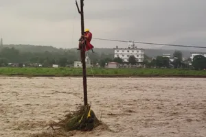 Nhân viên cứu hộ giải cứu một thiếu niên trèo lên cây và dùng dây điện để cứu mình khỏi trận lũ lụt ở Uttarakhand. Ảnh : NDRF