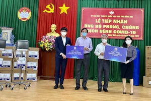 Bà Đặng Thị Kim Oanh (ngoài cùng bên phải), Chủ tịch Quỹ Từ thiện Kim Oanh tặng trang thiết bị y tế và gạo hỗ trợ tỉnh Đồng Nai phòng chống dịch