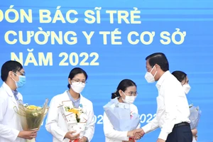 Chủ tịch UBND TPHCM Phan Văn Mãi chúc mừng các bác sĩ trẻ tăng cường về trạm y tế cơ sở. Ảnh: VIỆT DŨNG