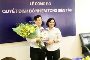 Đồng chí Thân Thị Thư, Trưởng Ban Tuyên giáo Thành ủy TPHCM, tặng hoa chúc mừng tân Tổng Biên tập Báo Người Lao động Tô Đình Tuân. Ảnh: KIỀU PHONG