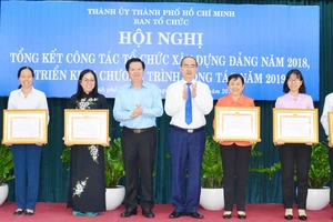 Bí thư Thành ủy TPHCM Nguyễn Thiện Nhân và Phó Trưởng Ban Tổ chức Trung ương Mai Văn Chính, chúc mừng các tập thể được nhận bằng khen. Ảnh: KIỀU PHONG