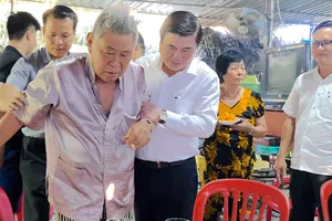 Chủ tịch UBND TPHCM ân cần thăm hỏi sức khỏe ông Huỳnh Quang Hải và gia đình ông. Ảnh: KIỀU PHONG