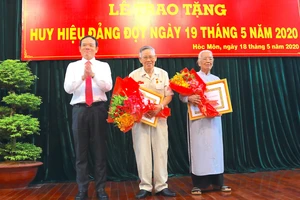  Đồng chí Trần Lưu Quang, Phó Bí thư Thường trực Thành ủy TPHCM trao Huy hiệu Đảng cho đảng viên cao tuổi Đảng thuộc Đảng bộ huyện Hóc Môn, sáng 18-5-2020. Ảnh: ANH CHÂU