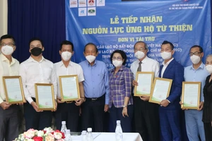 Nguyên Phó Thủ tướng Chính phủ Trương Hòa Bình và các đại biểu chụp hình lưu niệm tại lễ trao tặng