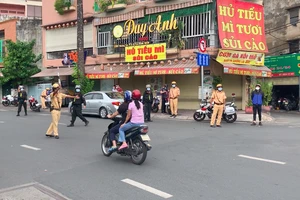 Công an quận Tân Bình làm việc với 1 trường hợp tham gia lưu thông trên địa bàn. Ảnh: CHÍ THẠCH 