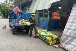 Anh Quang phát tiền hỗ trợ cho người dân. Ảnh: BẢO TRÂN 