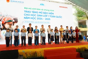 Lãnh đạo các đơn vị trao tặng mũ bảo hiểm cho học sinh ở Trường Tiểu học Giồng Ông Tố (phường Bình Trưng Tây, TP Thủ Đức).