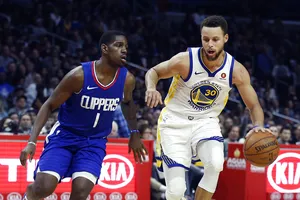 Stephen Curry (phải) trước sự theo đuổi của một cầu thủ LA Clippers