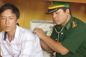 Anh Thâu đang được cán bộ Đồn BP Cửa Lò-Bến Thủy kiểm tra sức khỏe. Ảnh: T.B