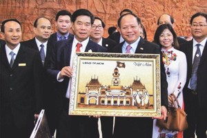 畢成剛同志向首都萬象領導贈送米畫。（圖片來源：互聯網）