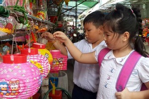 兒童在梁汝學街陳富店選購花燈。