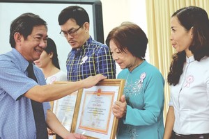 　　市紅十字會主席黎光寧醫生向做好紅十字工作的學 校頒發獎狀。