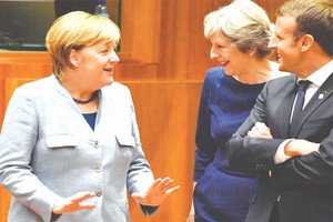 英首相特蕾莎‧梅（中）與德總理默克爾（左）及法國總統馬克龍言談甚歡。