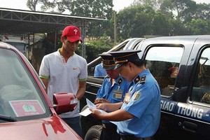 市交通檢查幹部在檢查一Uber司機的駕駛證件。