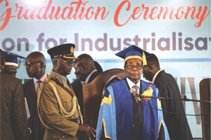 穆加貝現身一所大學的畢業典禮上（右一）。