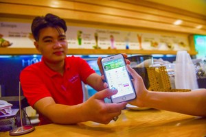 客戶在餐廳透過電子錢包付款。