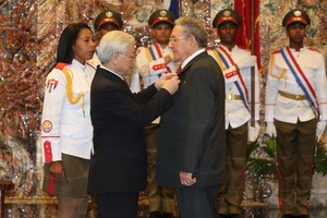 阮富仲總書記向卡斯特羅同志授予金星勳章。