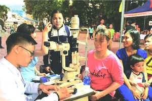 眼科醫生給少數民族同胞檢查視力。