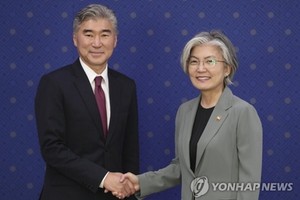 6月1日下午，在首爾外交部大樓，韓國外長康京和（右）和美國駐菲律賓大使金成握手合影。（韓聯社）