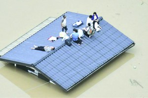 民眾爬上屋頂等 待救援。