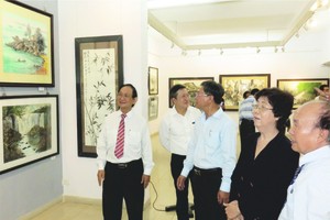 張路（右一）向各位領導及貴賓介紹畫展。