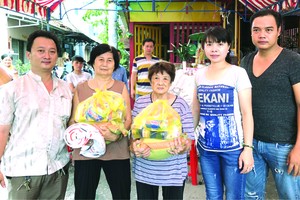 鄒國榮組長(左一)將禮物贈送給貧困戶。