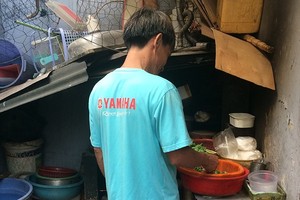 雄叔在狹窄的小屋裡準備飯菜。