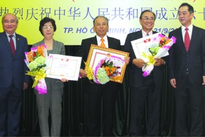 市各友好組織聯合會主席黃明善(左一)和 中國駐本市總領事吳駿(右一)祝賀獲表彰的集 體與個人。