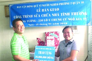 該坊領導(右)向李英家屬移交修繕房屋善款。