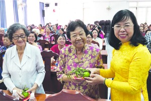 市婦聯會副主席杜氏政（右一）向民族婦女 派發紅包。