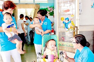 第十街區婦女分會在氏藝殘疾-孤兒收養中心照顧病童。