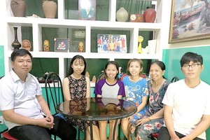 SOS村負責人陳煌俊（左）和黃氏玉耶母子們在其溫馨住宅中合影。