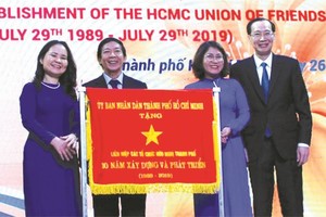 市人委會常務副主席黎清廉(右一)向市友聯會領導贈送市人委會傳統錦旗。