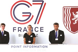 在法國比亞里茨，工作人員在新聞中心迎接媒體記者。