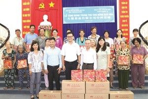 黃副總經理與本報領導向華人贈送月餅。