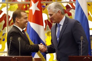 10月3日，在古巴哈瓦那，古巴國務委員會主席兼部長會議主席迪亞斯—卡內爾（右）與俄羅斯總理梅德韋傑夫握手。(圖源：新華社)