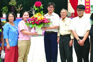 啟秀華文中心校委、老師和學生送花向亞洲餅家 及高慧芳小姐(左三)致謝。