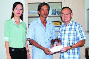 本報編委兼編輯部主任范興（右一）向畢業祥轉交5000萬元建溫情屋經費。