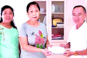 本報編委兼編輯部主任范興(右一)向林秀蓉移交4000萬元修繕房屋經費。