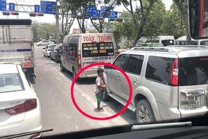 小孩子在本市-隆城-油曳高速公路與梅志壽街交叉路段行乞。