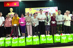 楊文德董事長（前排右六）贈送禮物給貧戶。