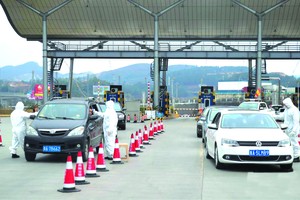 工作人員正在對車輛上的乘客進行體溫檢測，以防控新型冠狀病毒感染的肺炎疫情。