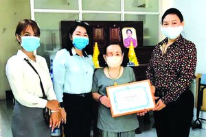 　　市婦聯會副主席陳氏芳華(右一)向殘疾 婦女頒發獎狀。