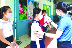 明道小學給五年級學生量體溫。