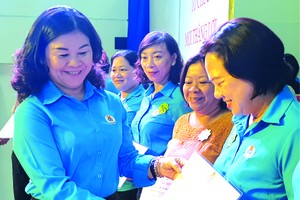 第五郡勞動聯團主席黎氏碧幸向女職工頒發模範獎。