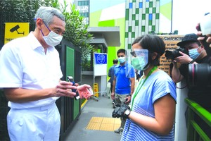 新加坡總理李顯龍（左）來到一處投票站投票。